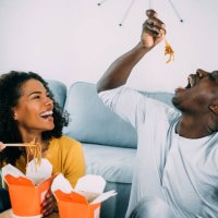 happy couple eating chinese food at home. - junk food stock pictures, royalty-free photos & images