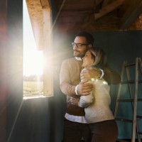 happy couple embracing by the window frame at construction site. - home decoration stock pictures, royalty-free photos & images