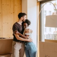 happy couple embracing each other while standing near window at new home - home decoration stock pictures, royalty-free photos & images