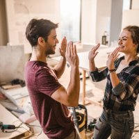 happy couple giving each other high-five at their renovating apartment. - home decoration stock pictures, royalty-free photos & images