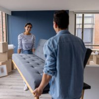 happy couple moving house and carrying a couch together - home decoration stock pictures, royalty-free photos & images