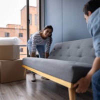 happy couple moving house and carrying a couch - home decoration stock pictures, royalty-free photos & images