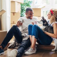 happy couple playing with dog while sitting at doorway in new house - home decoration stock pictures, royalty-free photos & images