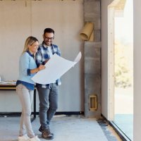 happy couple reading blueprints of their developing house. - home decoration stock pictures, royalty-free photos & images