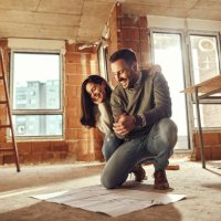 happy couple reading plans at their renovating apartment. - home decoration stock pictures, royalty-free photos & images