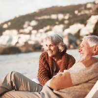 happy couple relaxing on chairs at beach - travel photos et images de collection
