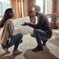 happy couple talking about plans at their renovating apartment. - home decoration stock pictures, royalty-free photos & images