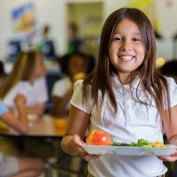 happy elementary school girl with healthy food in cafeteria - food stock pictures, royalty-free photos & images