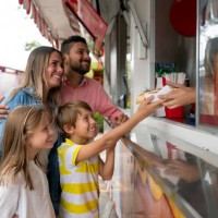 happy family buying food at an amusement park - food stock pictures, royalty-free photos & images