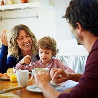 happy family enjoying breakfast at table - food stockfoto's en -beelden