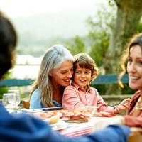 happy family sitting at outdoor meal table - garden decoration photos et images de collection