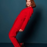 happy fashionable woman posing standing in red pantsuit studio shot on blue background indoors - fashion stock pictures, royalty-free photos & images