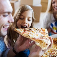 happy father and daughter eating pizza for lunch after moving into new home. - junk food stock pictures, royalty-free photos & images