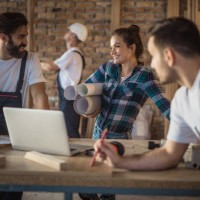 happy female architect talking to construction workers during home renovation process. - home decoration stock pictures, royalty-free photos & images