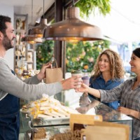 happy female friends buying take out food at a coffee shop - junk food stock pictures, royalty-free photos & images