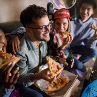 happy friends eating pizza for dinner on a party at home. - junk food stock pictures, royalty-free photos & images