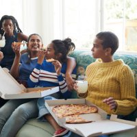 happy friends enjoying slumber party with pizza and juice - junk food stock pictures, royalty-free photos & images