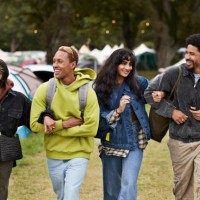 happy friends walking arm in arm at campsite - concert stock pictures, royalty-free photos & images