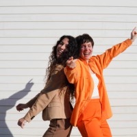 happy gay couple dancing together in front of white wall - fashion stock pictures, royalty-free photos & images