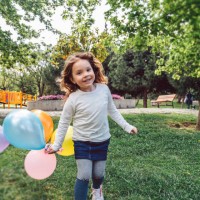 happy kid girl playing with colorful bunch of balloons - garden decoration stock pictures, royalty-free photos & images