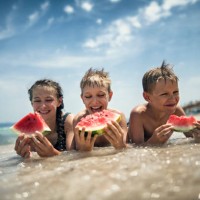 happy kids eating watermelon on the beach - food stock pictures, royalty-free photos & images