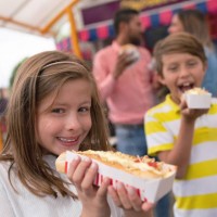 happy kids eten junkfood bij een pretpark - junk food stockfoto's en -beelden