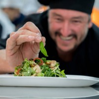 happy male chef adding details to a salad and smiling - home decoration stock pictures, royalty-free photos & images
