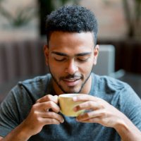 happy man drinking a cup of coffee at a cafe - coffee stock pictures, royalty-free photos & images