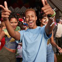 happy man gesturing while dancing with female friends - concert stock pictures, royalty-free photos & images