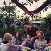 happy man serving water to friend during dinner party at yard - garden decoration stock pictures, royalty-free photos & images
