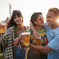 happy man with arm around girlfriend near friend - concert stock pictures, royalty-free photos & images