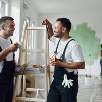 happy manual workers talking on a break inside of renovating apartment. - home decoration stock pictures, royalty-free photos & images