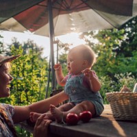 happy mother and daughter baby with harvest in garden having fun. - garden decoration photos et images de collection