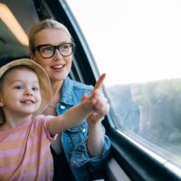 happy mother and daughter having fun while riding on the train together - travel stock pictures, royalty-free photos & images