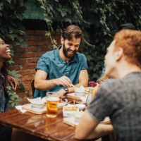 happy multi-ethnic group of people laughing at the restaurant - food stock pictures, royalty-free photos & images