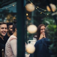 happy multi-ethnic young friends sitting at dining table during party in back yard - garden decoration stock pictures, royalty-free photos & images