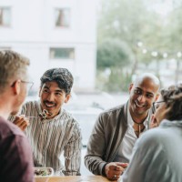 happy multiracial male and female colleagues having lunch together in restaurant - food stock pictures, royalty-free photos & images