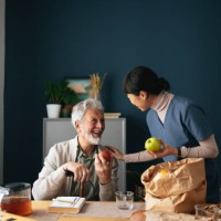 happy nurse delivering groceries to senior man at his home - food stock pictures, royalty-free photos & images