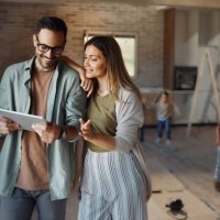 happy parents using digital tablet in their new home. - home decoration stock pictures, royalty-free photos & images