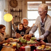 happy senior woman serving a meal to her family in dining room. - home decoration stock pictures, royalty-free photos & images