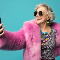 happy senior woman wearing jewelry taking selfie through smart phone against turquoise background - fashion stock pictures, royalty-free photos & images