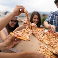 happy students eating pizza together on a party - junk food stock pictures, royalty-free photos & images