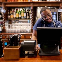 happy waiter talking a delivery order on the phone while working at a restaurant - junk food stock pictures, royalty-free photos & images