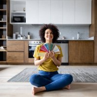 happy woman at home choosing a color to paint the walls - home decoration stock pictures, royalty-free photos & images
