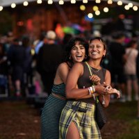 happy woman embracing female friend at concert - concert stock pictures, royalty-free photos & images
