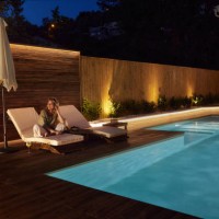 happy woman enjoying on a deck chair by the pool at night. - garden decoration photos et images de collection