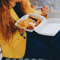 happy woman enjoying outdoor takeaway meal - junk food stock pictures, royalty-free photos & images