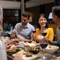 happy woman having dinner with a group of friends - food stock pictures, royalty-free photos & images
