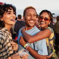 happy woman hugging boyfriend near female friend - concert stock pictures, royalty-free photos & images