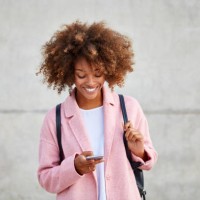 happy woman text messaging through mobile phone - fashion stock pictures, royalty-free photos & images